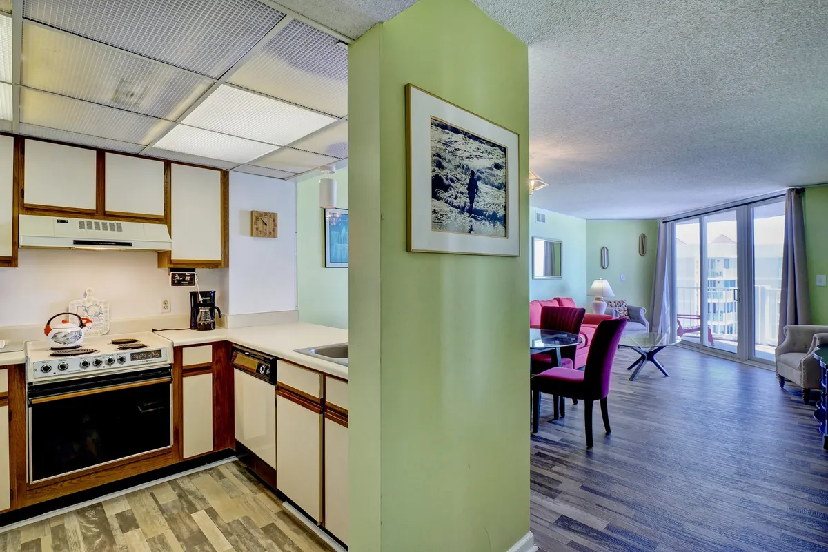 This image features a spacious kitchen with modern appliances, a connected dining area, and large windows that let in ample natural light. The open layout allows for socializing and enjoying the view while preparing meals, creating a welcoming and practical cooking environment.